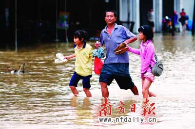 樂昌市政府前和街道被水浸,一位家長帶著孩子涉水而行?！　」攘⑤x童銅韶朱裕超攝