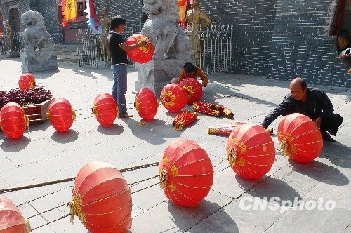 8月31日，河南省開封市天波楊府門口，工作人員在準備懸掛大紅燈籠。隨著“十一”國慶節(jié)和“十一”旅游黃金周的臨近，古城開封的公園景點已早早開始備戰(zhàn)，營造喜慶祥和的旅游環(huán)境，迎接八方客人。 中新社發(fā) 李俊生 攝