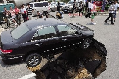4日，南昌市昌南大道與迎賓北大道交叉口附近路面突然發(fā)生塌陷，一輛過路小轎車被卡在洞口處。圖/新華社