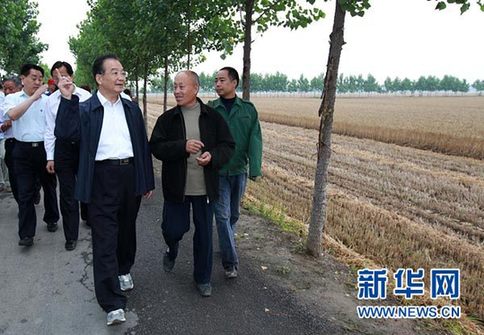 這是6月9日，溫家寶在長(zhǎng)葛市石象鄉(xiāng)坡李王村的田間小路上與坡李王村支部書記李福成邊走邊聊。新華社記者龐興雷攝