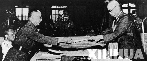 日本中國派遣軍總司令官岡村寧次在對華投降書上簽字，并向中方交出他的隨身佩刀，以表示侵華日軍正式向中國繳械投降。這是何應(yīng)欽(左)在南京代表中國政府接受侵華日軍總司令岡村寧次的投降書。新華社發(fā)