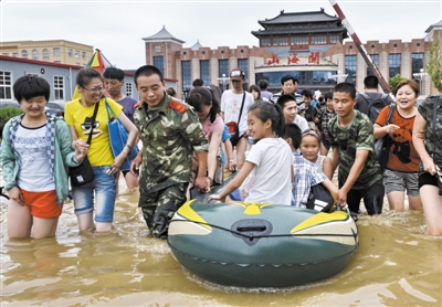 昨日，消防戰(zhàn)士在秦皇島市山海關(guān)火車站涉水運送旅客。當日，受持續(xù)強降雨影響，河北省秦皇島市海港區(qū)、山海關(guān)區(qū)等地出現(xiàn)內(nèi)澇，部分列車停運。 新華社發(fā)