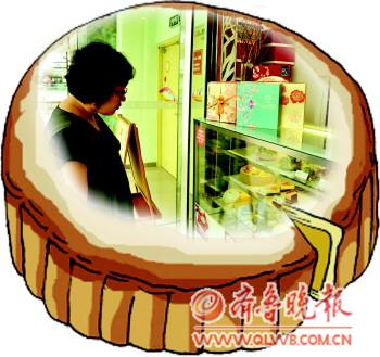 甜品店柜臺(tái)上精致的月餅禮盒引來顧客駐足觀看。