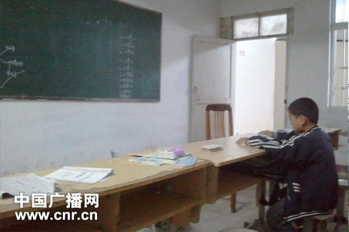 木板隔開的二年級(jí)教室中，只剩小華（化名）一個(gè)學(xué)生