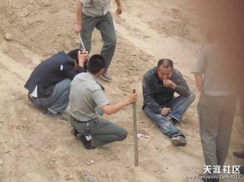 陜AWK707的西安城管執(zhí)法車和6名穿制服的城管，手持棍棒，在郊外毆打兩名倒地男子。 