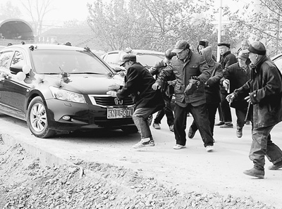 一些老人蜂擁而上圍堵婚車。