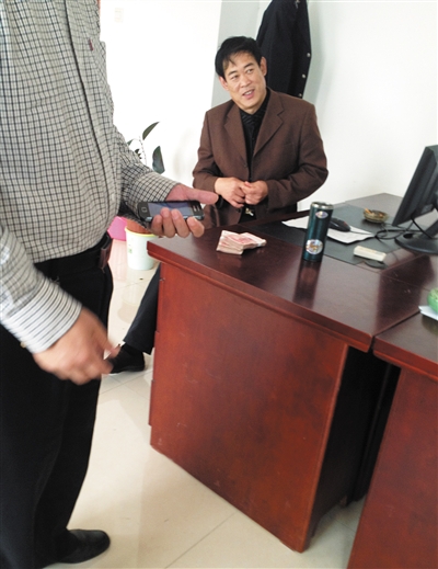 10月29日，獻(xiàn)縣國稅局稽查局辦公室內(nèi)，一名企業(yè)主交了兩萬元現(xiàn)金在桌上。新京報記者 孟祥超 攝