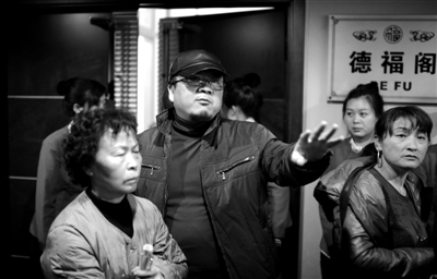 昨日，在河北香河天下第一城，相關(guān)負責人（左二）走出會議室與參加演出的老人們溝通。