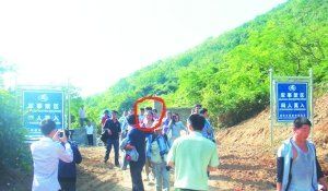 被困女子（圈中）獲救后從山嶺入口處豎有“軍事禁區(qū)”的標(biāo)牌旁通過。