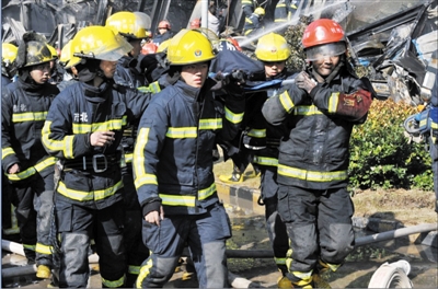 消防官兵將受傷的同事抬出。陳福 攝