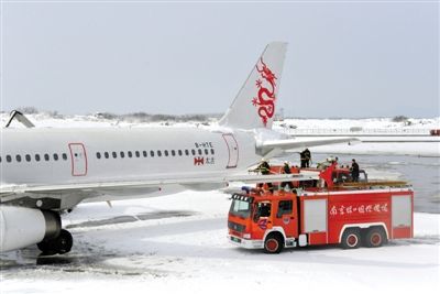2月19日，南京祿口國際機場工作人員在清理飛機上的積雪。新華社發(fā)