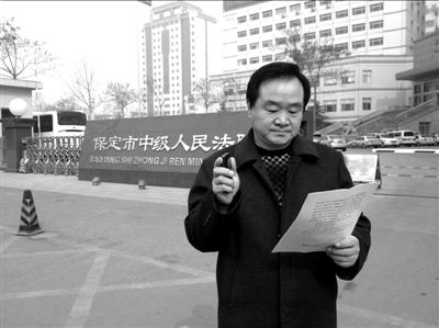 焦占軍在法院門口拿著決定書，無語站立。京華時報記者孫思婭攝
